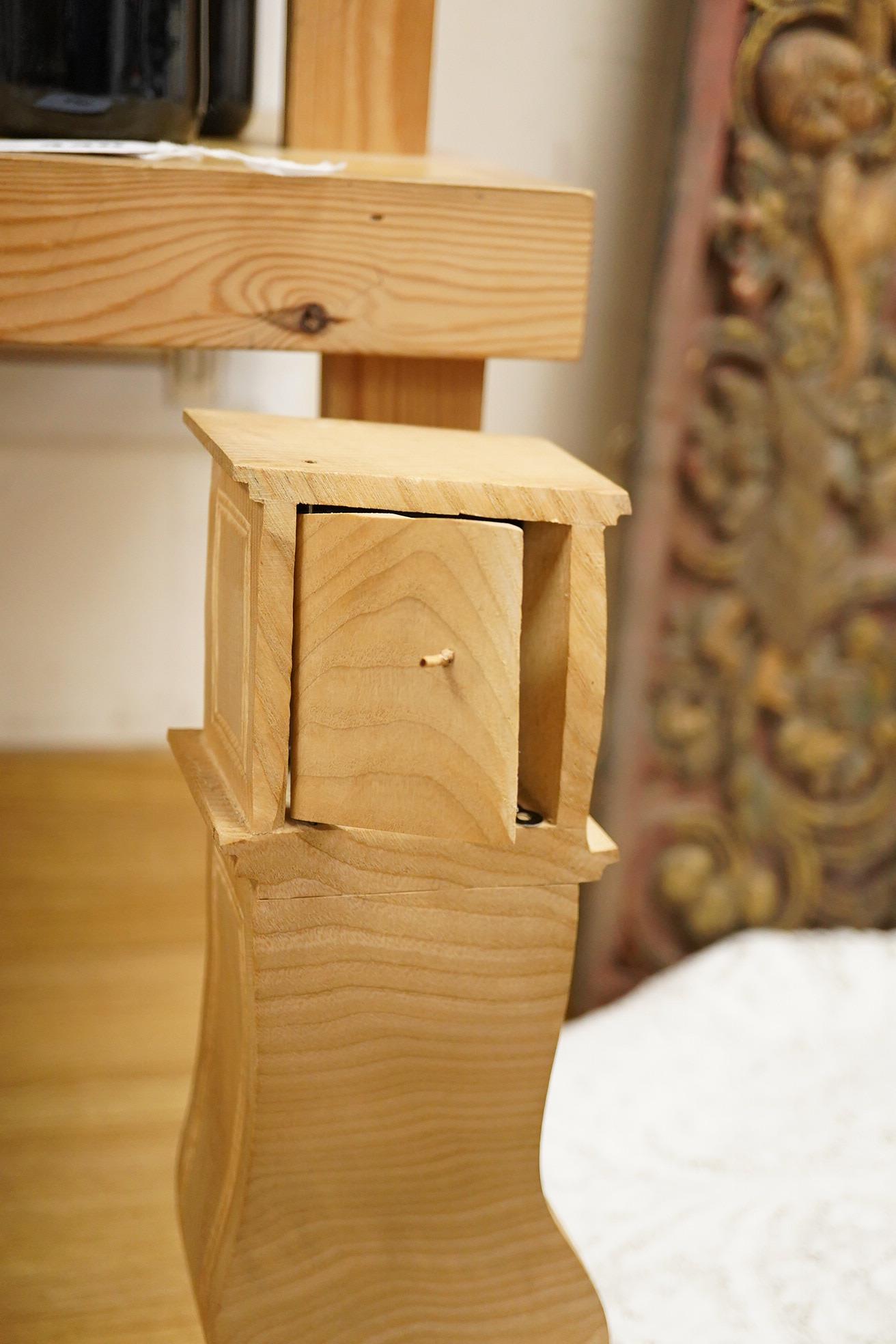 Pierre Decorse (b.1953), a naturalistically modelled wooden sculpture of a grandfather clock and a figure, together with two other sculptures comprising a suitcase and figure, largest 42cm high